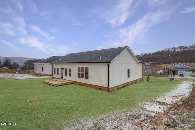 rear view of property featuring a deck with mountain view and a yard