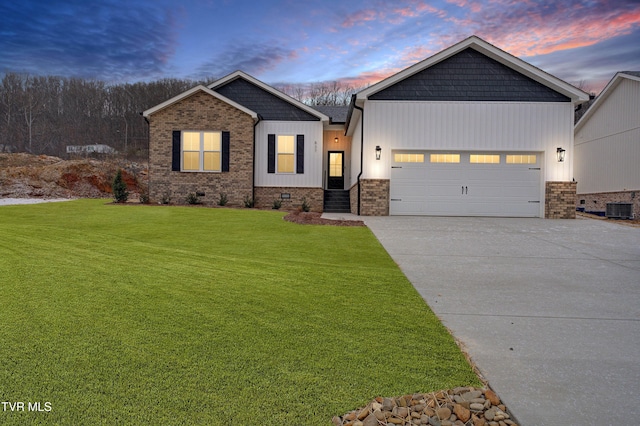 craftsman inspired home with a yard, a garage, and central air condition unit