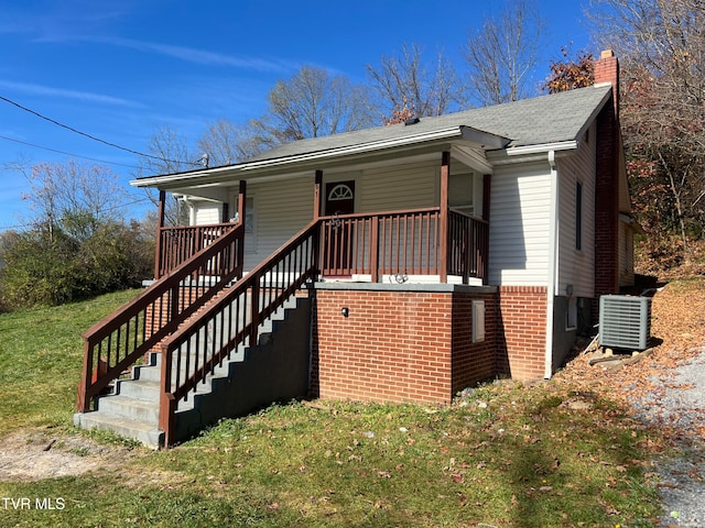 view of home's exterior with a yard, a porch, and central AC unit