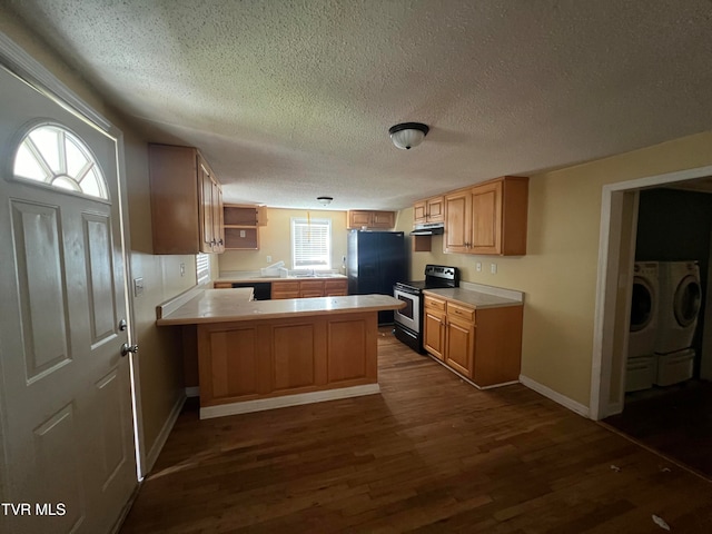 kitchen featuring kitchen peninsula, dark hardwood / wood-style flooring, a textured ceiling, washing machine and clothes dryer, and black appliances