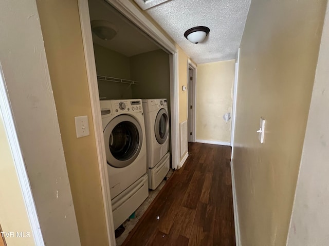 washroom featuring washing machine and dryer, a textured ceiling, and dark hardwood / wood-style floors