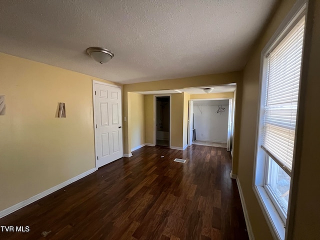 spare room with dark wood-type flooring and a textured ceiling