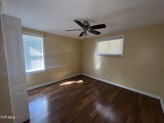 unfurnished room with dark wood-type flooring, ceiling fan, and a healthy amount of sunlight