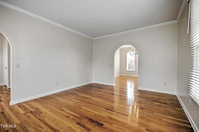 empty room with wood-type flooring and ornamental molding