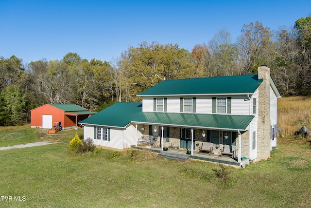 view of front of property with an outbuilding, a front lawn, and a porch