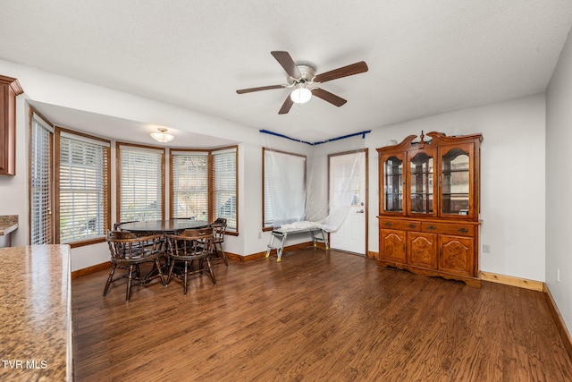 dining room with dark hardwood / wood-style floors, ceiling fan, and a textured ceiling