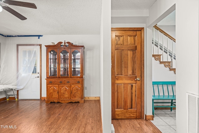 foyer with a textured ceiling, light hardwood / wood-style flooring, and ceiling fan