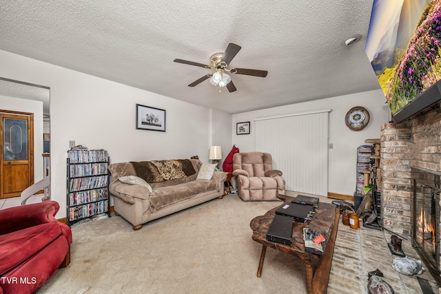 carpeted living room with ceiling fan, a fireplace, and a textured ceiling