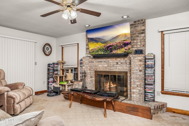 carpeted living room featuring a fireplace, a textured ceiling, and ceiling fan