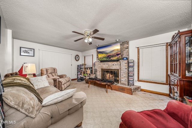 carpeted living room featuring a textured ceiling, ceiling fan, and a fireplace