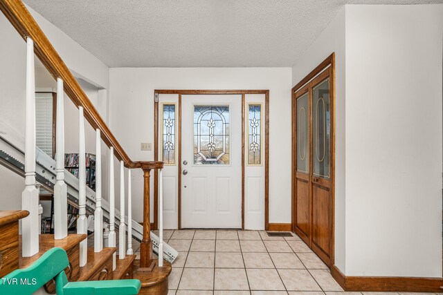 tiled foyer featuring a textured ceiling