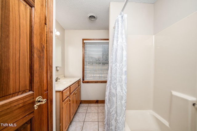 bathroom featuring tile patterned flooring, vanity, shower / bathtub combination with curtain, and a textured ceiling