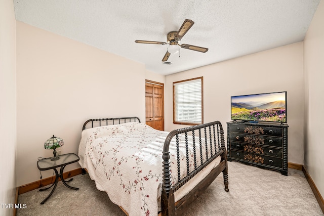 bedroom with ceiling fan, a closet, carpet, and a textured ceiling