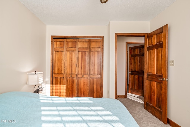 bedroom with dark carpet, a textured ceiling, and a closet