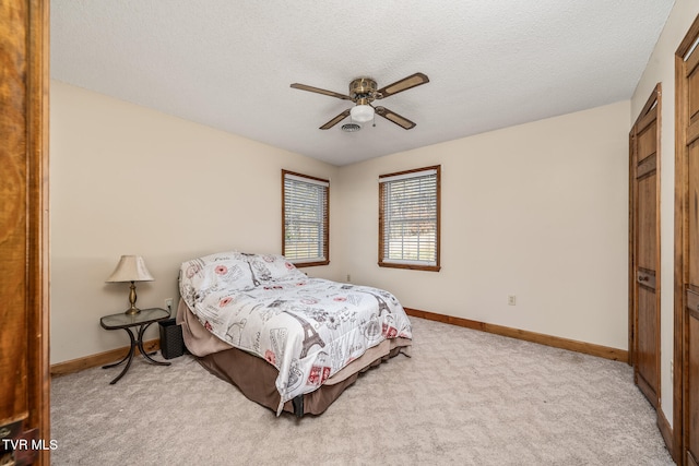 carpeted bedroom with a textured ceiling, a closet, and ceiling fan