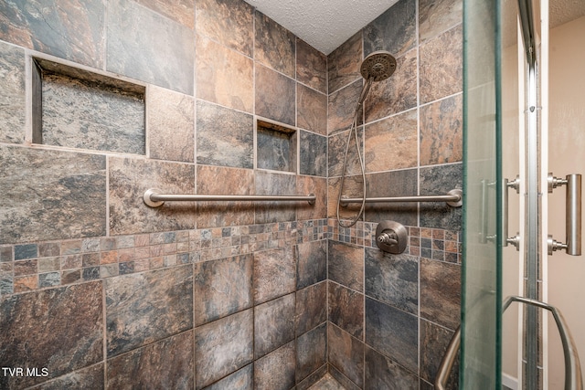 details with a textured ceiling and an enclosed shower