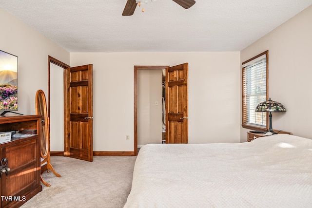 carpeted bedroom featuring ceiling fan and a textured ceiling