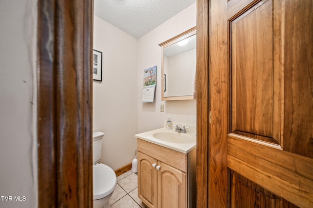 bathroom with toilet, a textured ceiling, vanity, and tile patterned floors