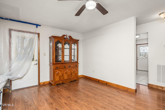 interior space featuring hardwood / wood-style floors, ceiling fan, and a textured ceiling