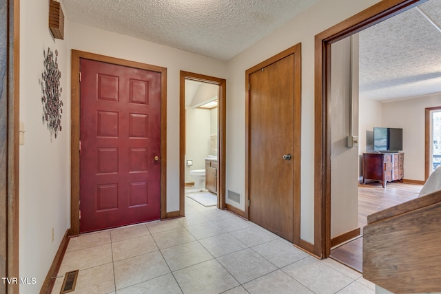 entryway with light hardwood / wood-style floors and a textured ceiling