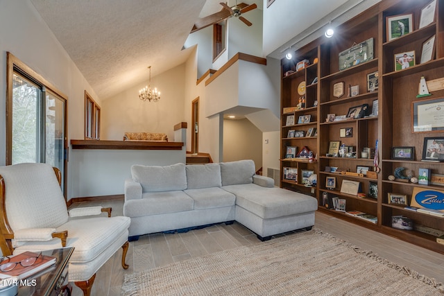 living room featuring high vaulted ceiling, light wood-type flooring, a textured ceiling, and ceiling fan with notable chandelier