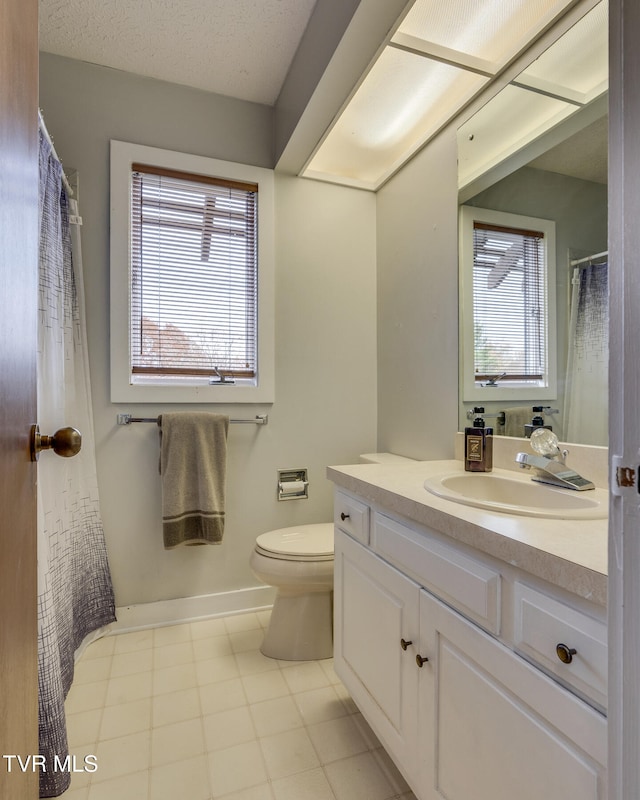 bathroom with vanity, toilet, and a textured ceiling