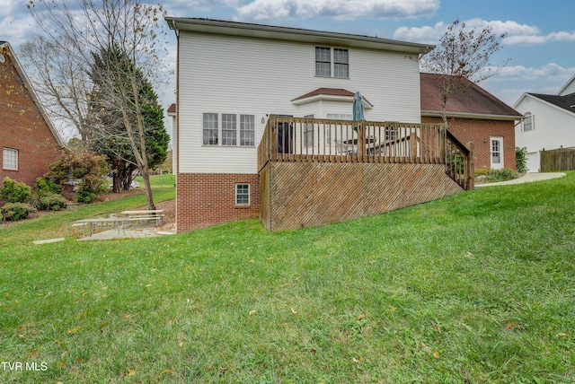 rear view of house featuring a lawn and a deck