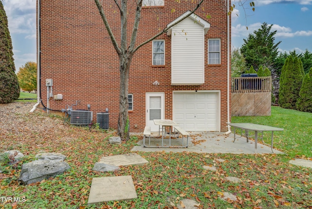 rear view of house featuring central AC unit and a garage