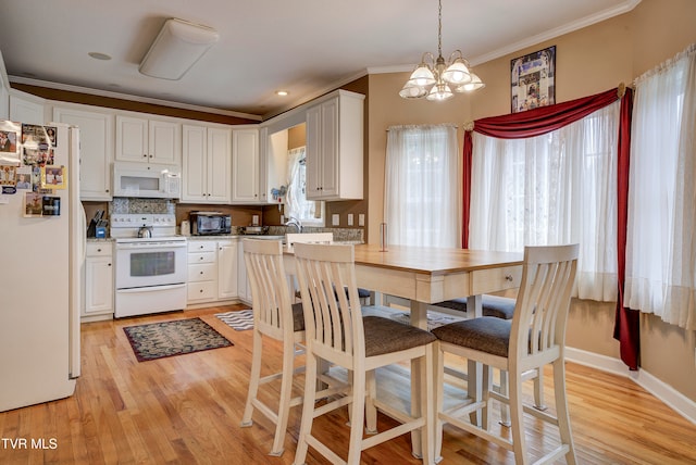 kitchen featuring decorative light fixtures, a notable chandelier, light hardwood / wood-style floors, white cabinets, and white appliances