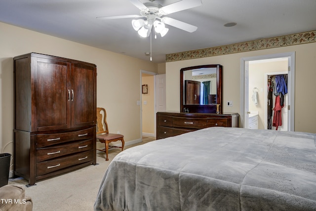 bedroom featuring light colored carpet, ceiling fan, and ensuite bath