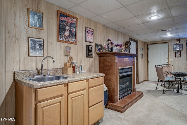 bar featuring a paneled ceiling, sink, and light colored carpet