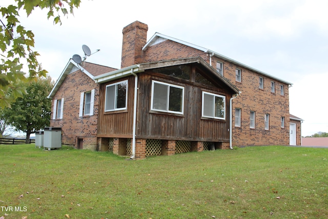 view of home's exterior with central AC unit and a lawn