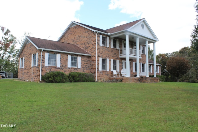 view of front facade with a front yard and a balcony