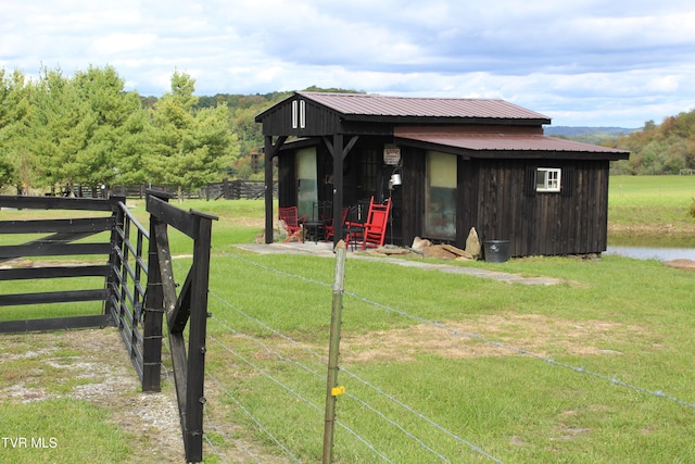 exterior space featuring an outdoor structure, a front lawn, and a rural view