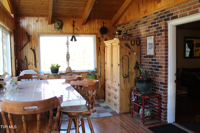 dining area with wood walls, light wood-type flooring, and a wealth of natural light