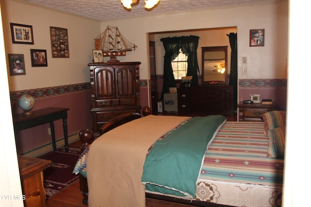 bedroom with hardwood / wood-style flooring and a textured ceiling