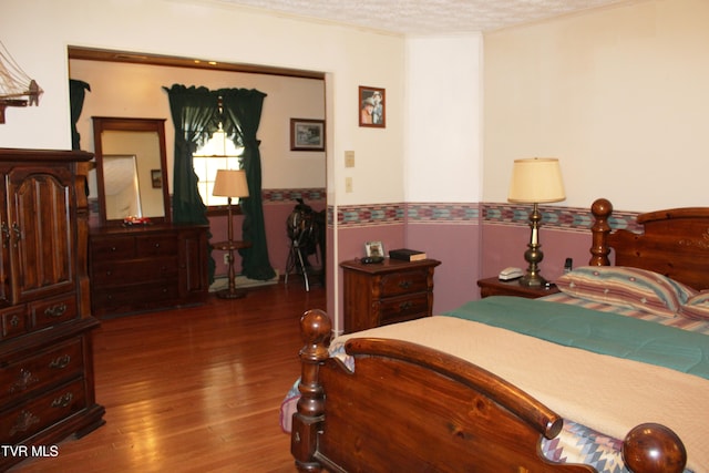 bedroom featuring hardwood / wood-style floors and a textured ceiling