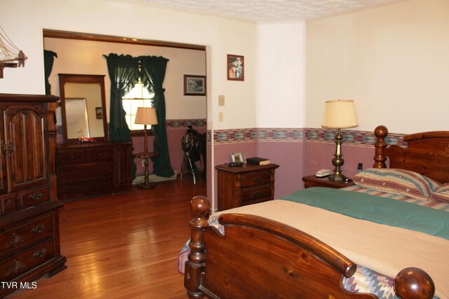 7362 Jim Faust Rd, Wise, VA 24293 - bedroom featuring a wainscoted wall, wood finished floors, and a textured ceiling