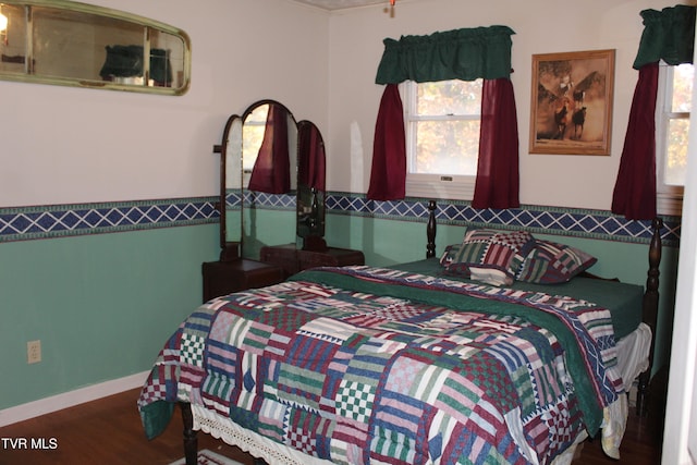 bedroom with multiple windows and wood-type flooring