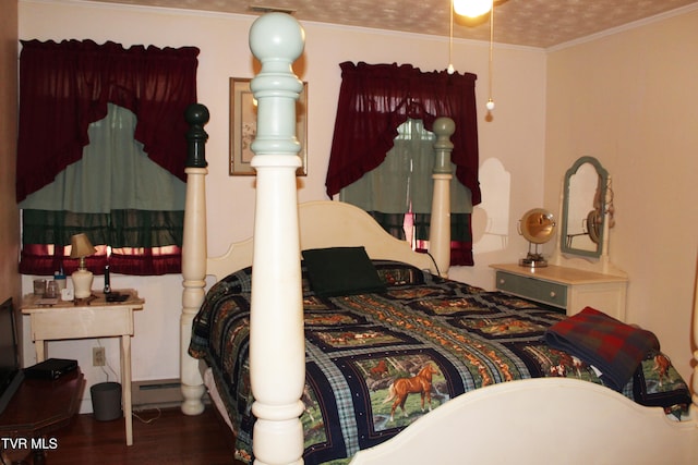 bedroom with a textured ceiling, dark hardwood / wood-style flooring, and ornamental molding