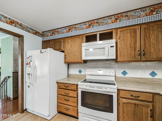 kitchen featuring decorative backsplash, white appliances, and light hardwood / wood-style flooring