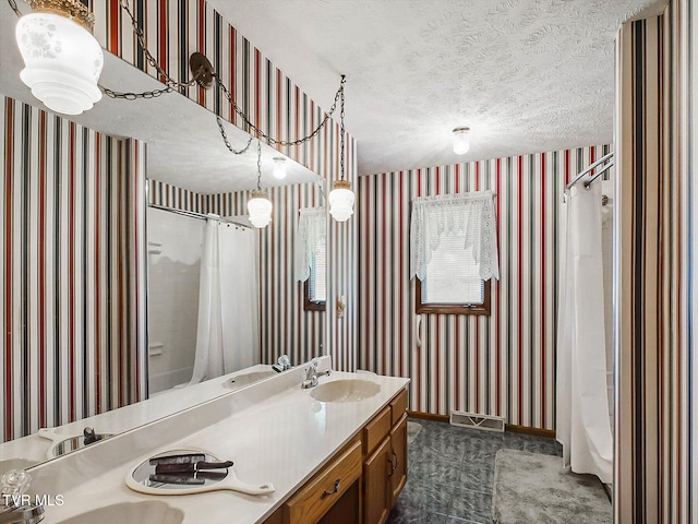 bathroom featuring shower / bath combo with shower curtain, vanity, and a textured ceiling