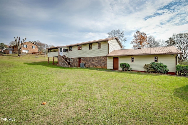 back of house featuring a lawn, central AC unit, and a deck