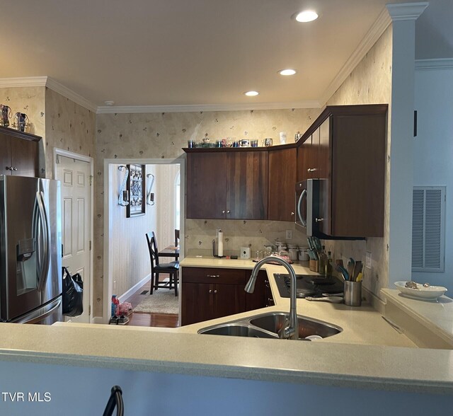 kitchen featuring dark brown cabinets, stainless steel appliances, sink, and crown molding