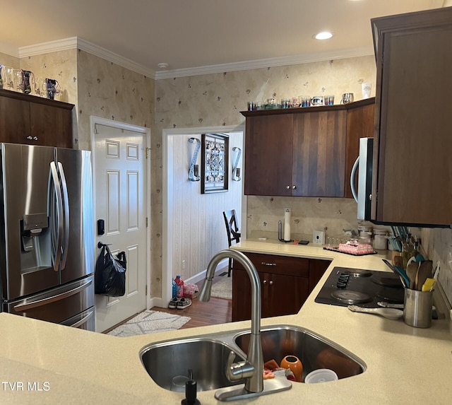 kitchen with dark brown cabinetry, stainless steel appliances, sink, and crown molding