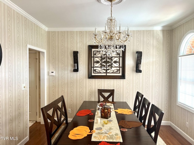 dining area featuring dark wood-type flooring, a notable chandelier, and ornamental molding