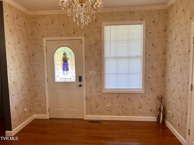 entrance foyer with wood-type flooring, a notable chandelier, and crown molding