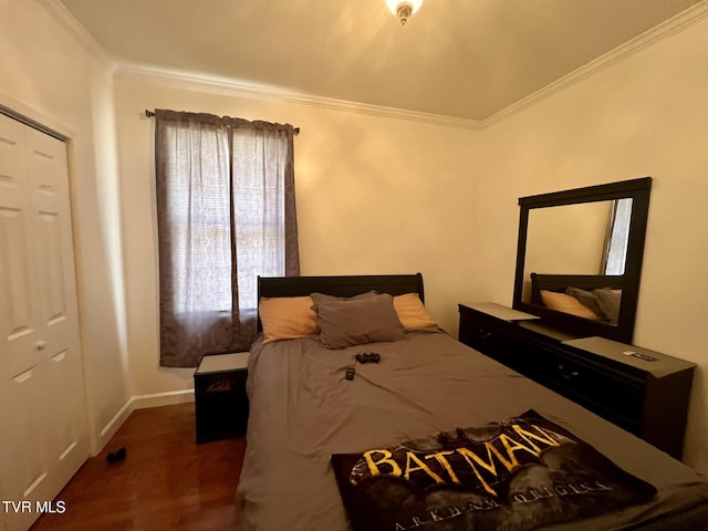 bedroom with a closet, dark hardwood / wood-style floors, and crown molding