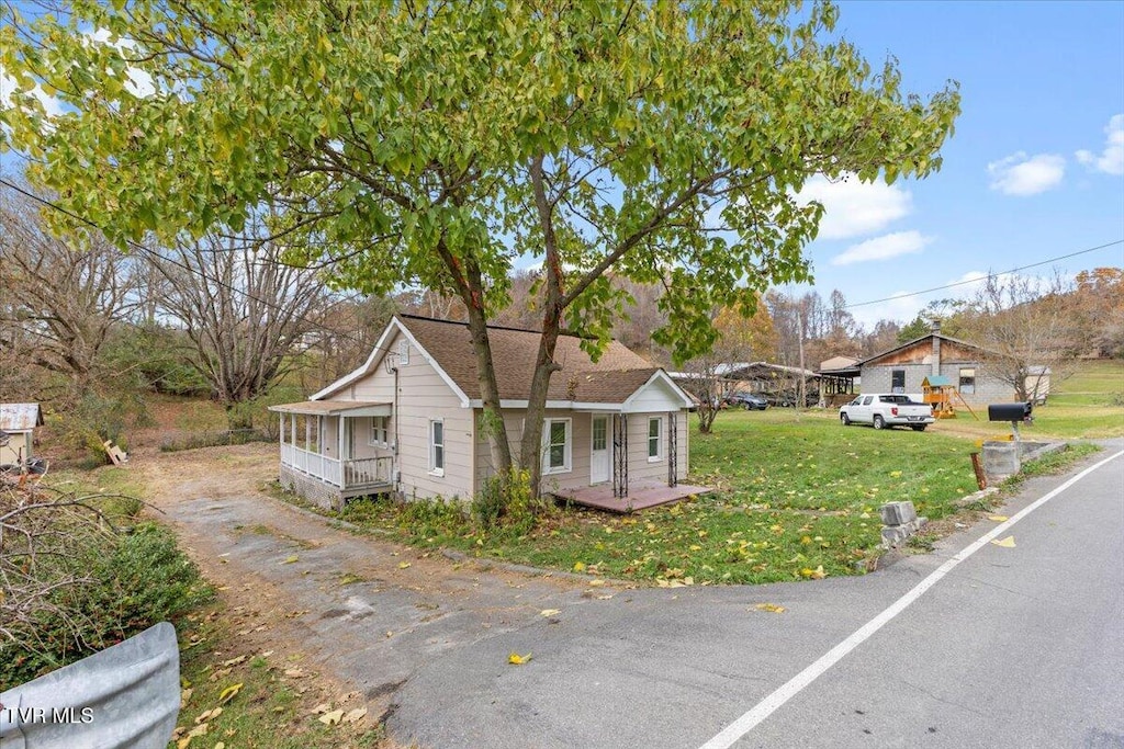 bungalow-style home with a front yard and covered porch