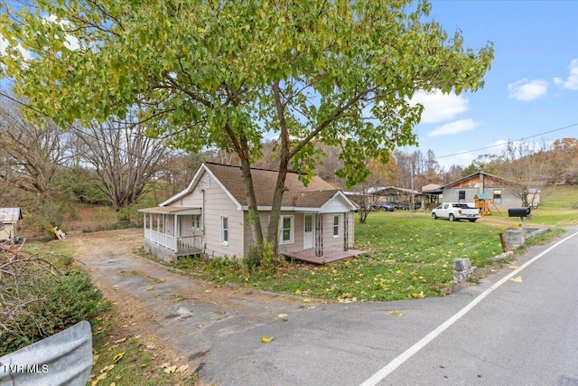 bungalow-style home with a front yard and covered porch